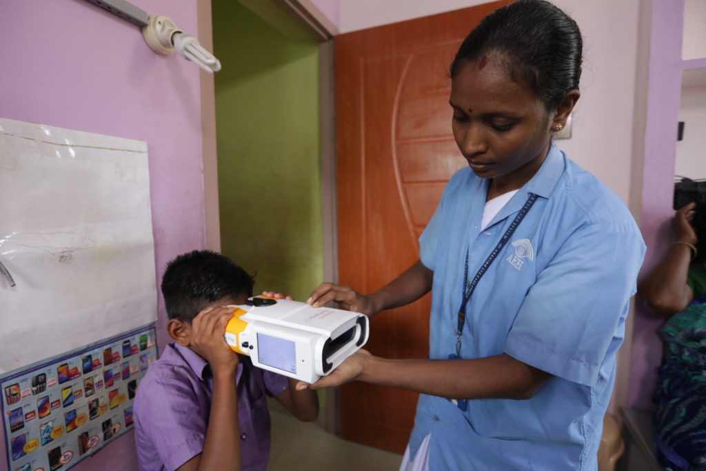 Woman refracting child with QuickSee in Indian clinic