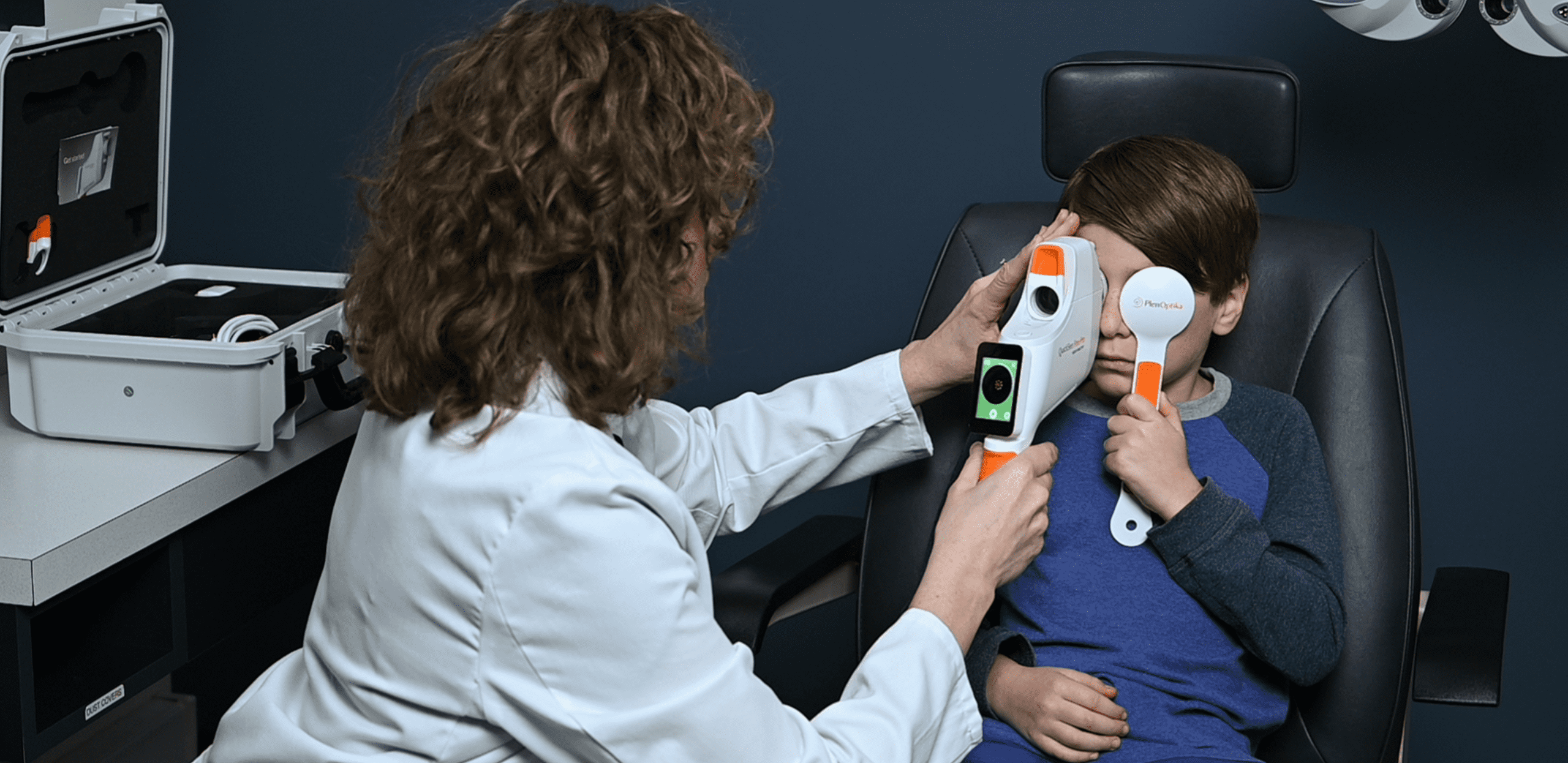 An optometrist measuring a pediatric patient's vision with the QuickSee Free Pro handheld wavefront autorefractor