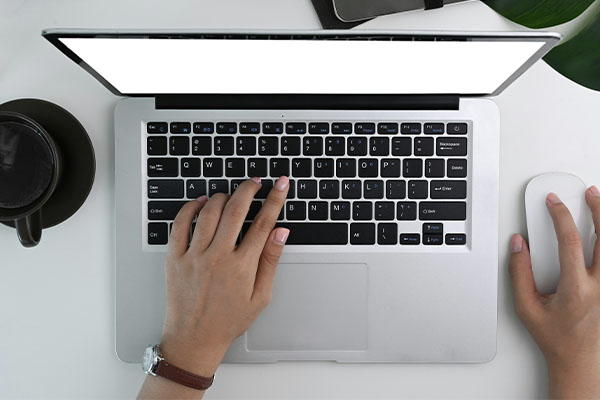 Hands on a laptop keyboard and mouse